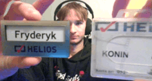 a man wearing headphones holds up a card that says fryderyk helios