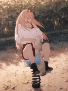 a girl with horns is sitting on a seesaw in the sand