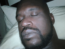 a man with a beard is sleeping on a bed