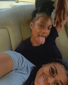 a woman sticking her tongue out next to another woman in a car