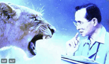 a man is sitting in front of a lion with a gif alt button below him