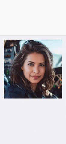 a woman with short hair is sitting in a car and smiling