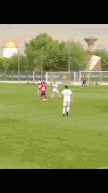 a group of soccer players are playing on a field with a sign that says fc barcelona in the background