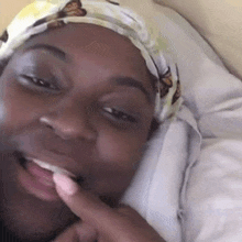 a woman wearing a headband with butterflies on it is smiling while laying in bed .