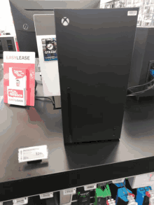 a black xbox is on display in a store with a sign that says easylease