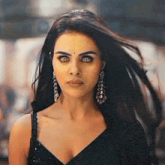 a close up of a woman wearing earrings and a black dress