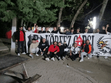 a group of men holding up a banner that says " bejk " on it