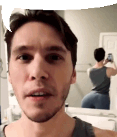 a man is taking a selfie in front of a mirror