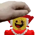 a person is putting a towel on top of a lego figure with a spider on it 's face .