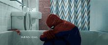 a man in a spiderman costume sits in a bathtub under a shower curtain that says haensi dag