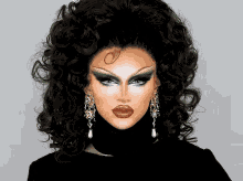 a close up of a drag queen 's face with a turtleneck and earrings