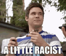 a man in a blue and white striped shirt is holding a lighter with the words a little racist written on it