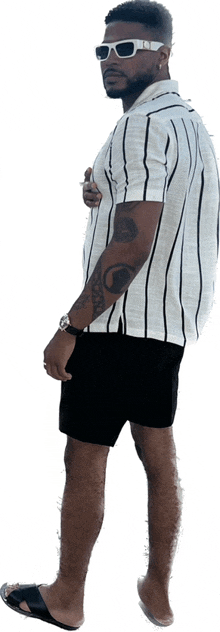 a man with a tattoo on his arm is wearing shorts and a striped shirt