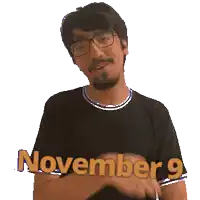 a man wearing glasses and a black shirt with the words november 9 on it