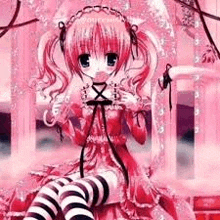 a girl in a pink dress and black and white striped thigh high socks is sitting on a brick wall .