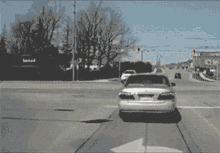 a black and white photo of cars driving down a street with a sign in the background that says ' lg '