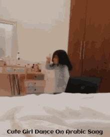 a little girl is dancing on a bed with the words cute girl dance on arabic song