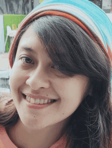 a close up of a woman 's face with a striped hat on