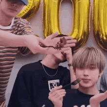 a group of young men are holding a piece of cake in their hands and eating it with a fork .