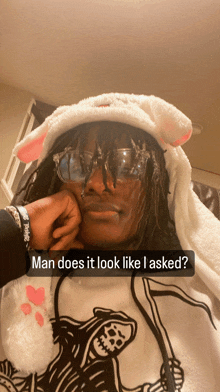 a man wearing a bunny hat and glasses has a caption that says man does it look like i asked