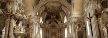 the inside of a church with a cross on the altar and paintings on the walls .