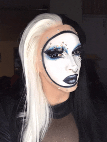 a woman with a black and white face paint and rhinestones on her face