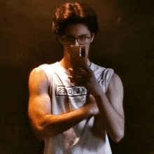 a young man is taking a selfie in front of a mirror .