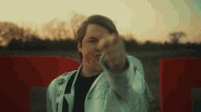 a man in a white jacket is pointing his finger