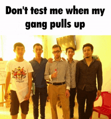 a group of young men are posing for a picture with the caption " don 't test me when my gang pulls up "