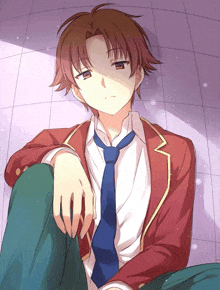 a boy in a red jacket and tie sits on the floor