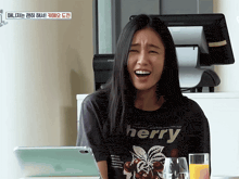 a woman wearing a t-shirt that says cherry is smiling