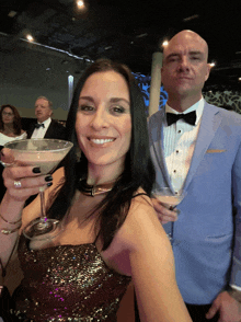 a woman holding a martini glass next to a man in a suit