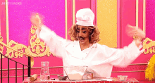 a woman in a chef 's hat is standing in front of a table with a bowl of flour on it .