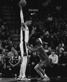 a black and white photo of two basketball players with the words just prey on the bottom