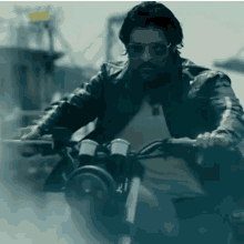 a man in a leather jacket is riding a bike