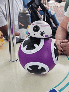 a purple and white robot with a straw in it