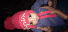 a baby wearing a red hat and a sweater