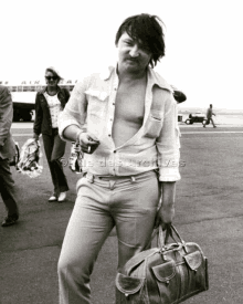 a black and white photo of a shirtless man carrying a bag with the words file des archives on the bottom