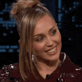 a close up of a woman 's face with a bun on her hair