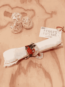 a napkin holder on a wooden table with a card that says felices fiestas