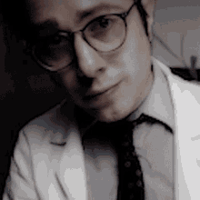 a man wearing glasses and a white lab coat