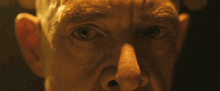 a close up of a man 's face with his eyes looking at the camera