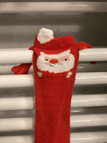 a red sock with santa claus on it hangs from a radiator