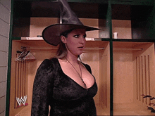 a woman in a witch costume is in a locker room with a w logo on the wall