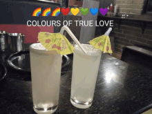 two drinks with straws and umbrellas on a table with the words colours of true love above them