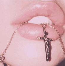 a close up of a woman 's lips with a cross necklace