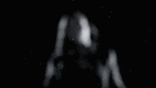 a black and white photo of a woman 's face in the dark .