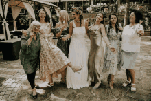 a group of women are posing for a picture with a bride in the middle