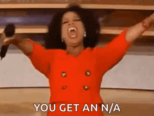 a woman in a red jacket is holding a microphone with her arms outstretched and says you get an n / a