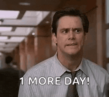 a man in a striped shirt and tie is standing in a hallway and says `` 1 more day ! ''